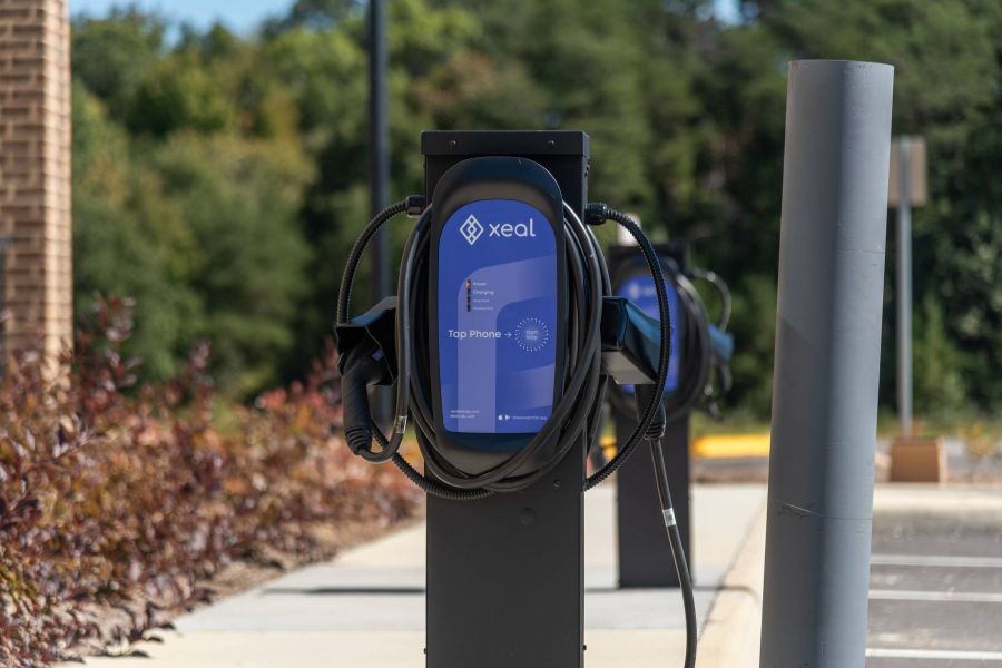 Acclaim at the Hill senior apartment homes with Close-up of a Xeal electric vehicle charging station in an outdoor parking lot on a sunny day.