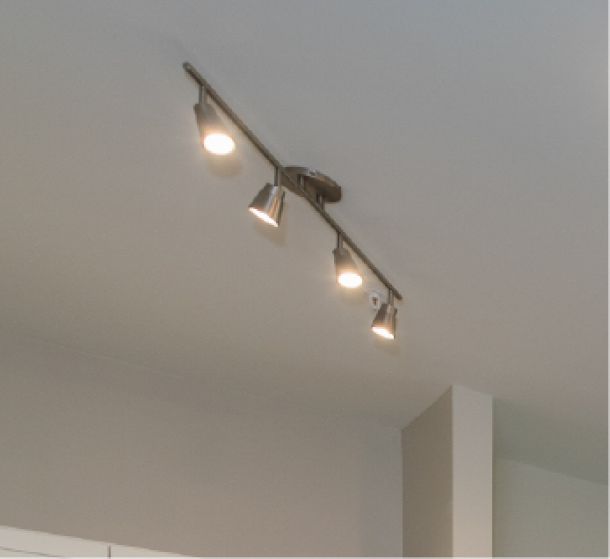 Acclaim at the Hill senior apartment homes with Three metal track lights mounted on a ceiling, all illuminated.